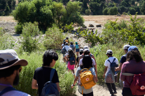 FoLAR's first cohort of River Fellows walk down a hiking path during their camping trip. 