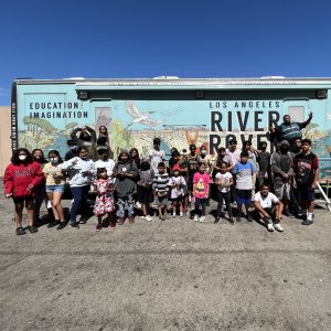 Students pose outside the River Rover on a clear day.