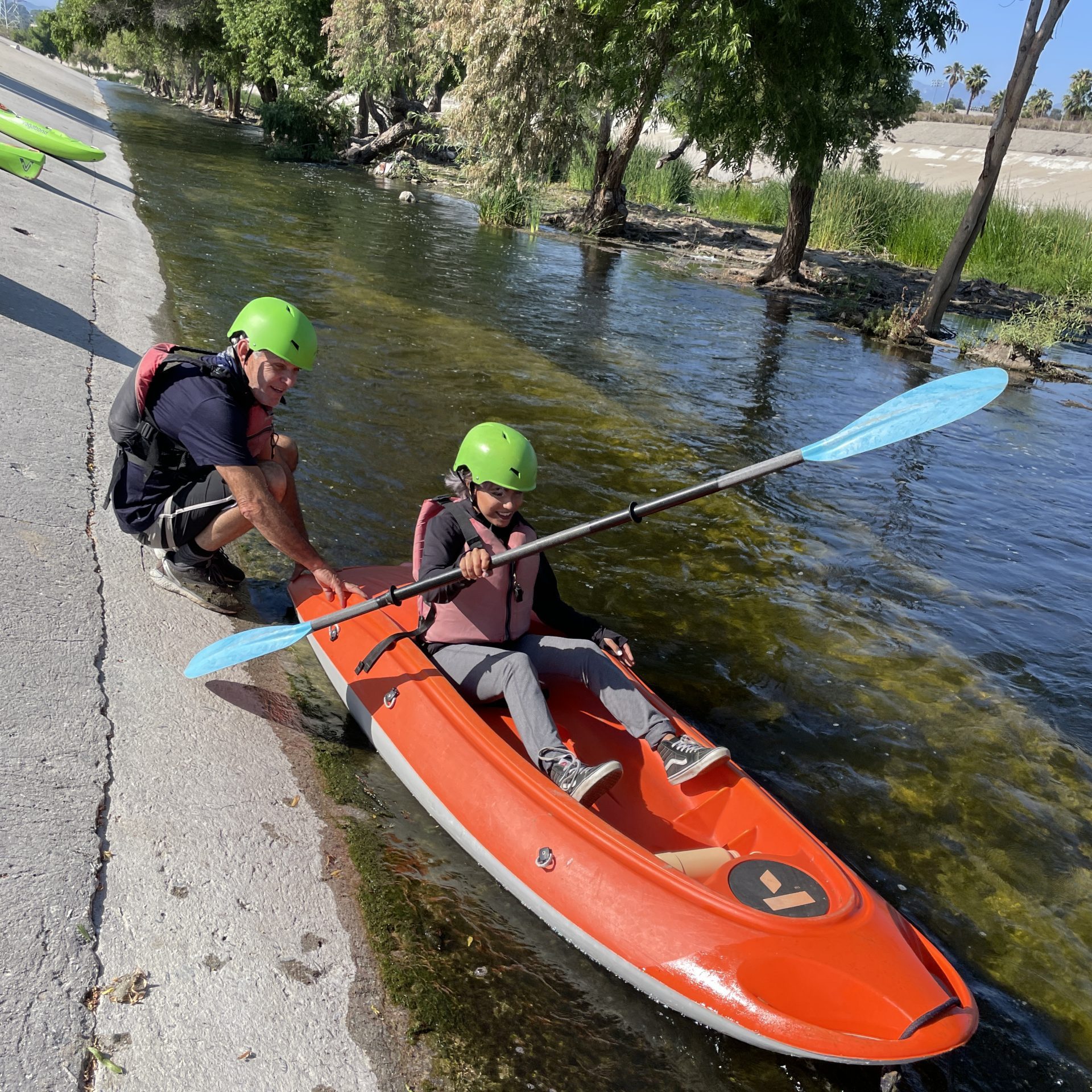 Young LA River Fellow on a Kayak on the edge of the LA River.